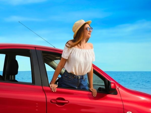 Woman driving by the coast in a Rental Car